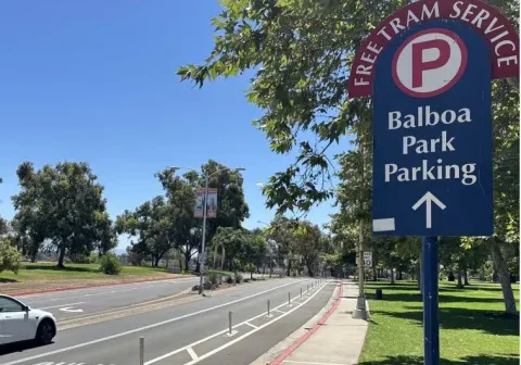 Balboa Park parking sign near road.